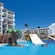 The pool area of a resort featuring a tropical themed play area for children with water slides and fountains